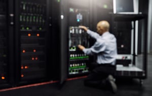 Mann bedient Terminal in einem Serverraum